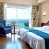 Disfrute de una escapada con desayuno en el Hotel Soho Boutique Las Vegas de Málaga. Esta acogedora habitación cuenta con dos cómodas camas, vistas al mar, un amplio ventanal, televisor, silla y cortinas decorativas para un refugio encantador. - ForTwo - Planes para parejas