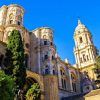 El Hilton Garden Inn en Málaga ofrece una escapada premium, ubicado entre catedrales históricas con una arquitectura ornamentada y árboles altos bajo un cielo azul claro, brindando una visión del rico pasado de Málaga. - ForTwo - Planes para parejas