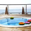 Disfrute de una "Escapada en Torremolinos con Suite 4 estrellas: Roc Lago Rojo" con piscina redonda en una terraza de madera con flores de loto flotantes, vistas al mar y relajación a la sombra de una sombrilla. - ForTwo - Planes para parejas