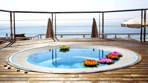 Disfrute de una "Escapada en Torremolinos con Suite 4 estrellas: Roc Lago Rojo" con piscina redonda en una terraza de madera con flores de loto flotantes, vistas al mar y relajación a la sombra de una sombrilla. - ForTwo - Planes para parejas