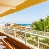 Disfrute de un soleado balcón con dos sillas blancas y una mesa en el Hotel Roc Flamingo. Con vistas a los edificios y al océano, es el lugar perfecto para una escapada a Torremolinos. Una gran palmera contribuye a la tranquilidad del lugar. - ForTwo - Planes para parejas