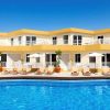 Descubre los encantadores Checkin Bungalows Atlántida en Tenerife, con alojamientos de dos plantas con vibrantes detalles en amarillo y lujosas tumbonas y sombrillas junto a una gran piscina, ideal para una escapada en pareja. - ForTwo - Planes para parejas