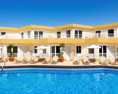 Descubre los encantadores Checkin Bungalows Atlántida en Tenerife, con alojamientos de dos plantas con vibrantes detalles en amarillo y lujosas tumbonas y sombrillas junto a una gran piscina, ideal para una escapada en pareja. - ForTwo - Planes para parejas