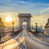 Al amanecer, el Puente de las Cadenas de Budapest ofrece vistas impresionantes con majestuosas estatuas de leones de piedra que custodian el camino bajo un cielo azul despejado. A pocos pasos, Escapada de fin de semana a Budapest: Prestige Hotel garantiza una escapada de fin de semana inolvidable. - ForTwo - Planes para parejas