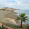 Experimente las vistas frente al mar de una costa de arena, palmeras y edificios cercanos bajo un cielo nublado, a solo unos pasos del Hotel Rincón Sol en el hermoso Rincón de la Victoria en la Costa del Sol. - ForTwo - Planes para parejas