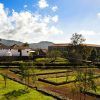 Disfrute de un paisaje pintoresco en La Casona del Patio, con exuberantes campos, linderos de piedra, árboles y encantadores edificios bajo un cielo azul nublado. Este idílico entorno encarna una auténtica "Escapada rural en Santiago del Teide". - ForTwo - Planes para parejas