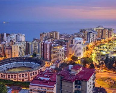 Experimente el atardecer en Málaga, una escapada ideal con su emblemática plaza de toros, puerto deportivo y edificios iluminados junto al mar. Tras un día explorando, el Hotel Soho Los Naranjos le espera. - ForTwo - Planes para parejas