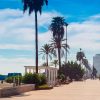 El paseo marítimo de Fuengirola, con sus palmeras y bancos, ofrece vistas pintorescas y es ideal para una vibrante escapada de fin de semana. Disfrute de un alojamiento práctico en los cercanos Apartamentos Mediterráneo Real, "Escapada de fin de semana a Fuengirola". - ForTwo - Planes para parejas