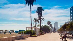 El paseo marítimo de Fuengirola, con sus palmeras y bancos, ofrece vistas pintorescas y es ideal para una vibrante escapada de fin de semana. Disfrute de un alojamiento práctico en los cercanos Apartamentos Mediterráneo Real, "Escapada de fin de semana a Fuengirola". - ForTwo - Planes para parejas