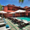Tumbonas y sombrillas rodean una piscina serena en el patio de "Escapada a 5 minutos de la playa en una villa de Tenerife", ubicada entre palmeras ondulantes, capturando el encanto relajado de las playas de Tenerife. - ForTwo - Planes para parejas