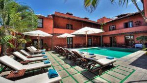Tumbonas y sombrillas rodean una piscina serena en el patio de "Escapada a 5 minutos de la playa en una villa de Tenerife", ubicada entre palmeras ondulantes, capturando el encanto relajado de las playas de Tenerife. - ForTwo - Planes para parejas
