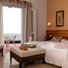 Disfrute de la Escapada en El Hierro con spa en el Hotel Balneario Pozo de la Salud. Su habitación ofrece una cómoda cama doble, una silla de mimbre y un balcón con vistas al mar. Disfrute de una decoración serena con cojines florales y obras de arte enmarcadas para un remanso de paz. - ForTwo - Planes para parejas