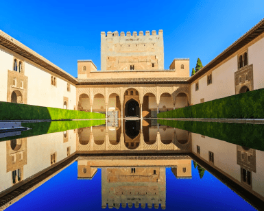 Bajo un cielo azul claro, descubra la piscina reflectante, el arco y la torre de los Palacios Nazaríes de la Alhambra con Entradas para Alhambra y Palacios Nazaríes: Visita guiada. - ForTwo - Planes para parejas