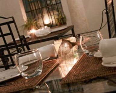 Restaurante Azahar (Sevilla) ofrece una elegante experiencia gastronómica con cristalería, servilletas blancas, manteles individuales tejidos y una linterna de vela, creando el ambiente perfecto de Sevilla. - ForTwo - Planes para parejas
