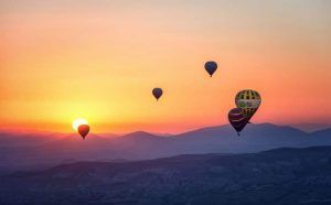 Experimente la magia de los globos aerostáticos flotando elegantemente sobre las montañas durante un colorido atardecer con Vuelo en globo con Barcelona Balloon Flights (Barcelona). - ForTwo - Planes para parejas