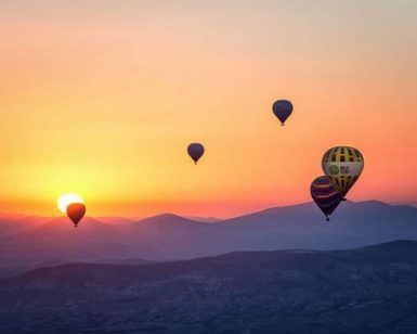 Experimente la magia de los globos aerostáticos flotando elegantemente sobre las montañas durante un colorido atardecer con Vuelo en globo con Barcelona Balloon Flights (Barcelona). - ForTwo - Planes para parejas