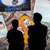 Dos personas admiran una exhibición de arte iluminada con texto e imágenes de Dragones y Modernismo en Barcelona: Experiencia inmersiva, que muestra el estilo modernista de Barcelona con cautivadores dragones míticos. - ForTwo - Planes para parejas