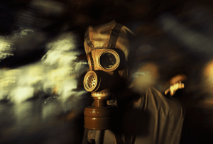 En medio de un escenario oscuro y borroso que evoca a Escape Room: Chernobyl 2.0, una figura vestida con una máscara de gas y un traje protector se prepara para el próximo desafío. - ForTwo - Planes para parejas