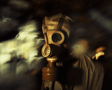 En medio de un escenario oscuro y borroso que evoca a Escape Room: Chernobyl 2.0, una figura vestida con una máscara de gas y un traje protector se prepara para el próximo desafío. - ForTwo - Planes para parejas