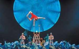 Bajo el cielo azul de Madrid, iluminado por la luna, "Luzia" del Circo del Sol deslumbra con un espectáculo acrobático impresionante. Una bailarina de equilibrio sobre zancos ilumina el escenario entre un vibrante tapiz de artistas en este espectáculo fascinante. - ForTwo - Planes para parejas