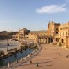 Únete al "Tour Gratuito a pie por Sevilla" en la Plaza de España para disfrutar del vibrante ambiente sevillano. Admira su emblemático edificio curvo y su fuente central mientras paseas con locales y turistas en un día soleado. - ForTwo - Planes para parejas