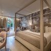 Disfrute de la elegante habitación del Gran Hotel Miramar Málaga, equipada con cama con dosel, sofá y escritorio. Relájese en el balcón con una serena vista al jardín y una relajante decoración en tonos neutros. - ForTwo - Planes para parejas