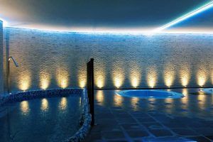 Experimente la tranquilidad en el Granada Palace & Spa con el "Circuito termal y masaje con piedras calientes". Disfrute de una tranquila piscina cubierta con paredes de piedra iluminadas, iluminación ambiental y un relajante jacuzzi. - ForTwo - Planes para parejas