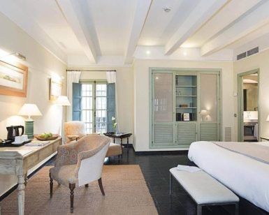 Disfrute de una espaciosa habitación en el Hotel Hospes Las Casas del Rey de Baeza, Sevilla, con una cama grande, cómodos sillones y un escritorio. Relájese viendo la televisión o admire las vistas desde el balcón a través de las puertas dobles en el encantador corazón de la ciudad. - ForTwo - Planes para parejas