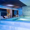 El Spa del Hospes Palacio de los Patos en Granada cuenta con una piscina cubierta con tumbonas, una relajante iluminación azul y un interior de mármol para un ambiente sereno. - ForTwo - Planes para parejas