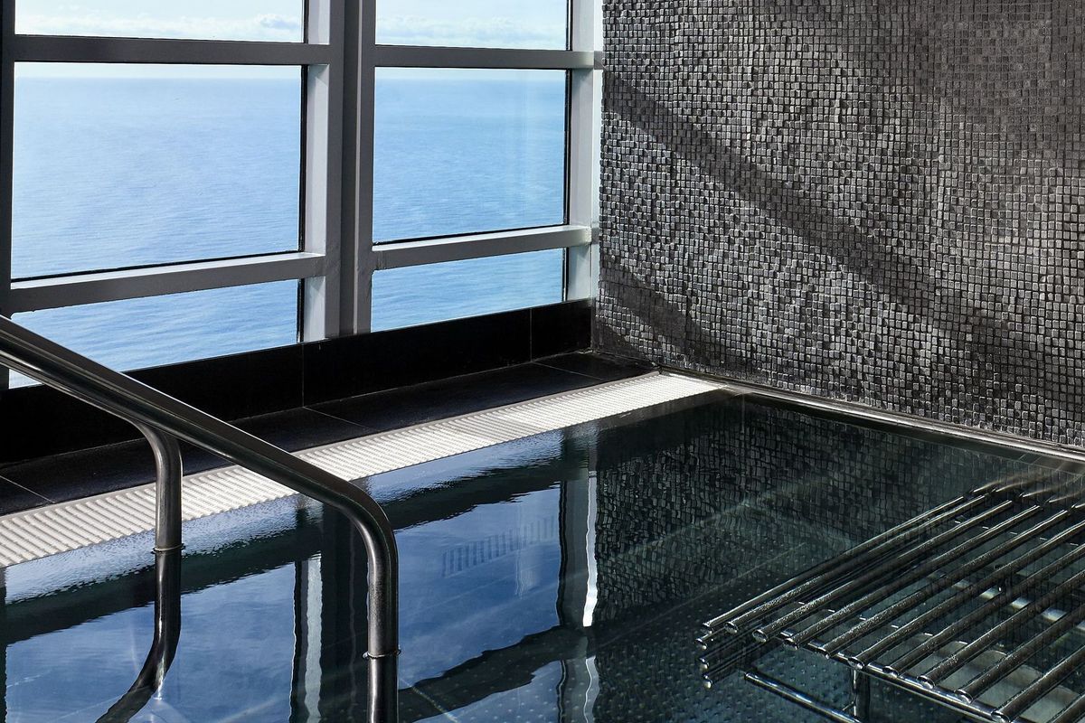 El Desayuno, Spa de Lujo y Masaje: La Experiencia Total en el Hotel Arts (Barcelona) cuenta con una piscina cubierta con mosaicos y barandillas metálicas, que ofrece impresionantes vistas al mar a través de grandes ventanales. - ForTwo - Planes para parejas