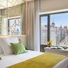 El Hotel Barceló Torre de Madrid ofrece una habitación moderna con un diseño elegante con acentos verdes, un gran ventanal y unas impresionantes vistas a la ciudad que capturan a la perfección el espíritu vibrante cerca de Torre de Madrid. - ForTwo - Planes para parejas