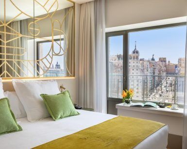 El Hotel Barceló Torre de Madrid ofrece una habitación moderna con un diseño elegante con acentos verdes, un gran ventanal y unas impresionantes vistas a la ciudad que capturan a la perfección el espíritu vibrante cerca de Torre de Madrid. - ForTwo - Planes para parejas