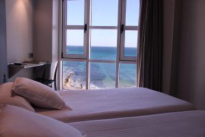 Disfrute de una escapada tranquila con "Escapada Romántica en el hotel Chiqui" (Santander), que ofrece una habitación con dos camas, escritorio y impresionantes vistas al mar a través de amplios ventanales. - ForTwo - Planes para parejas