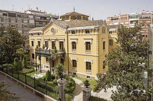 Situado en el paisaje urbano de Granada, el Hotel Hospes Palacio de los Patos Granada cuenta con un histórico exterior amarillo y un exuberante jardín, ofreciendo un oasis de serenidad bajo el cielo despejado. - ForTwo - Planes para parejas