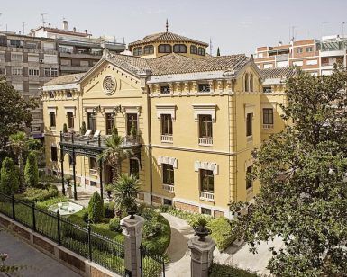 Situado en el paisaje urbano de Granada, el Hotel Hospes Palacio de los Patos Granada cuenta con un histórico exterior amarillo y un exuberante jardín, ofreciendo un oasis de serenidad bajo el cielo despejado. - ForTwo - Planes para parejas