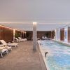 Relájese junto a la piscina interior del spa del Hotel Marina, Badalona, con tumbonas, iluminación tenue, toallas enrolladas y macetas. Disfrute de este ambiente tranquilo con nuestro exclusivo paquete de 60 minutos "Circuito Spa" y una exquisita comida en el Hotel Marina. - ForTwo - Planes para parejas