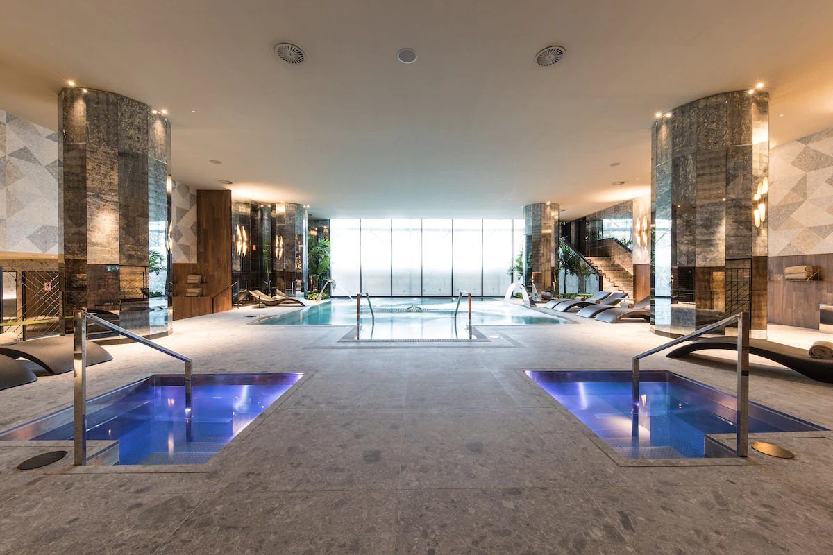 Disfrute de la máxima relajación en la piscina cubierta del Hotel SOFIA, con dos jacuzzis y tumbonas. Los amplios ventanales aportan luz natural, convirtiendo el Circuito Spa y Cena del Hotel SOFIA (Barcelona) en el destino perfecto para la tranquilidad y el rejuvenecimiento. - ForTwo - Planes para parejas