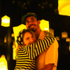 Una pareja se abraza y sonríe en medio del encantador resplandor de los faroles amarillos en la sala tenuemente iluminada de IKONO Madrid con sus Entradas para IKONO Madrid. - ForTwo - Planes para parejas