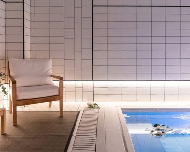 La acogedora piscina cubierta, con elegantes paredes de azulejos blancos, refleja el ambiente del Gran Hotel Inglés. Una silla de madera con cojines y un banco adornado con flores crean un remanso de paz ideal para relajarse después de disfrutar de un jacuzzi y un masaje privado en este distinguido hotel madrileño. - ForTwo - Planes para parejas