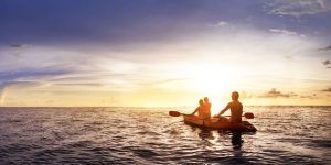 Dos personas disfrutando de un "Tour en kayak por Marbella" en el océano al atardecer, rodeadas de un cielo vibrante y aguas tranquilas. - ForTwo - Planes para parejas