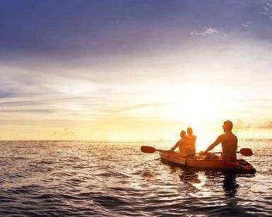 Dos personas disfrutando de un "Tour en kayak por Marbella" en el océano al atardecer, rodeadas de un cielo vibrante y aguas tranquilas. - ForTwo - Planes para parejas