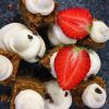 Primer plano de cuadrados de postre con remolinos de crema y fresas en rodajas en un plato azul oscuro, perfecto para un delicioso brunch en Brunch de comida local en MAAI Barcelona. - ForTwo - Planes para parejas