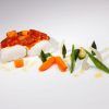 Disfrute de un plato gourmet del Menú degustación del Restaurante Montal en Zaragoza: tierno pescado con una rica salsa, bellamente adornado con zanahorias, espárragos y verduras vibrantes en un plato blanco impecable. - ForTwo - Planes para parejas