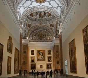 El ornamentado interior del Museo de Bellas Artes de Sevilla presenta un techo abovedado, grandes pinturas murales y los visitantes disfrutan de las "Entradas Museo de Bellas Artes de Sevilla: Visita guiada" para apreciar el arte. - ForTwo - Planes para parejas