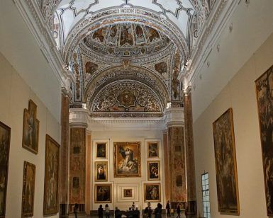 El ornamentado interior del Museo de Bellas Artes de Sevilla presenta un techo abovedado, grandes pinturas murales y los visitantes disfrutan de las "Entradas Museo de Bellas Artes de Sevilla: Visita guiada" para apreciar el arte. - ForTwo - Planes para parejas