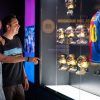 Dos visitantes admiran una exposición de trofeos dorados y una camiseta azul y roja con el número 10 en el Museo del Barça, disfrutando de un inolvidable Tour Inmersivo. - ForTwo - Planes para parejas