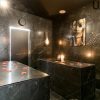 Experimente el lujoso Baño turco para parejas en Madrid (Hammam Vital Experience), con paredes de mármol oscuro, elegantes mesas, lámparas colgantes y pétalos de rosa. El ambiente sereno y el cautivador retrato mural lo convierten en el lugar perfecto para relajarse como nunca antes. - ForTwo - Planes para parejas