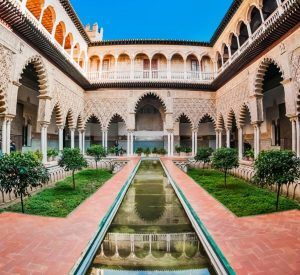 Descubra el Alcázar de Sevilla con el "Tour guiado al Alcázar de Sevilla (Entrada incluida)" y explore su ornamentado patio, su jardín simétrico y su estanque central. Disfrute de los intrincados detalles arquitectónicos para una experiencia inmersiva. - ForTwo - Planes para parejas