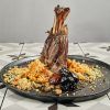 El Menú Al Ándalus del Restaurante Carmen El Agua (Granada) ofrece una pierna de cordero magníficamente presentada, complementada con cuscús, verduras y ciruelas pasas, celebrando la herencia culinaria de Granada. - ForTwo - Planes para parejas