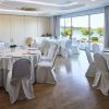 El elegante salón del Restaurante Marea Alta cuenta con mesas redondas con manteles y sillas blancas, ofreciendo un ambiente soleado y al aire libre, como el de Santander. Realce su celebración con el "Menú degustación en el restaurante Marea Alta (Santander)". - ForTwo - Planes para parejas
